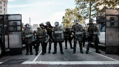 Law enforcement officers in riot gear standing in formation