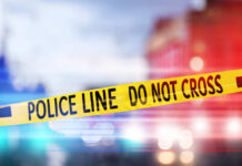 Yellow police tape reading DO NOT CROSS at a crime scene