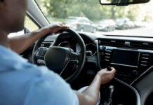 Drivers hands on the steering wheel inside a car