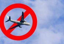 An airplane flying through a cloudy sky with a red prohibition symbol overlay