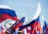 Multiple Russian flags waving in the wind at an outdoor event