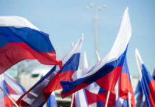 Multiple Russian flags waving in the wind at an outdoor event