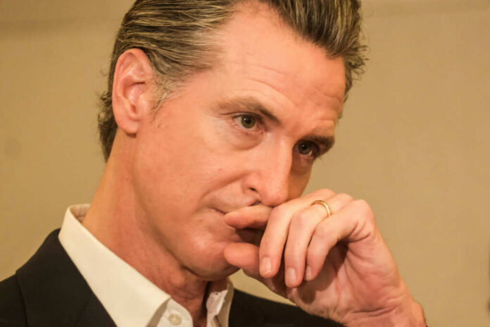 Close-up of a man in a suit with a thoughtful expression, hand on chin