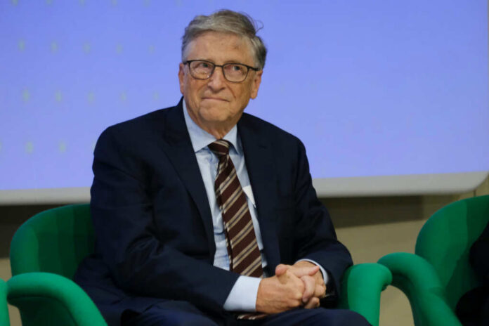 A man in a suit sitting on a green chair during a conference
