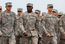 A group of U.S. Army soldiers marching in formation with serious expressions