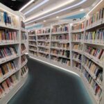 Interior view of a modern library with bookshelves filled with colorful books