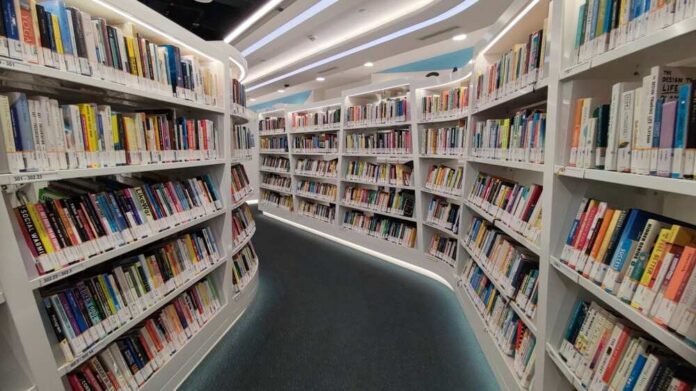 Interior view of a modern library with bookshelves filled with colorful books