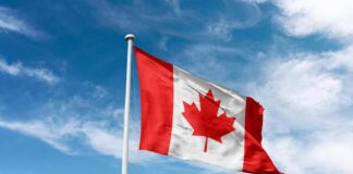Canadian flag waving against a blue sky