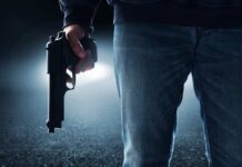 A person holding a handgun in a dark environment