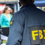 FBI Thwarts Synagogue Terror Plot FBI agent in a jacket with 'FBI' on the back at a public event