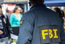 FBI agent in a jacket with 'FBI' on the back at a public event