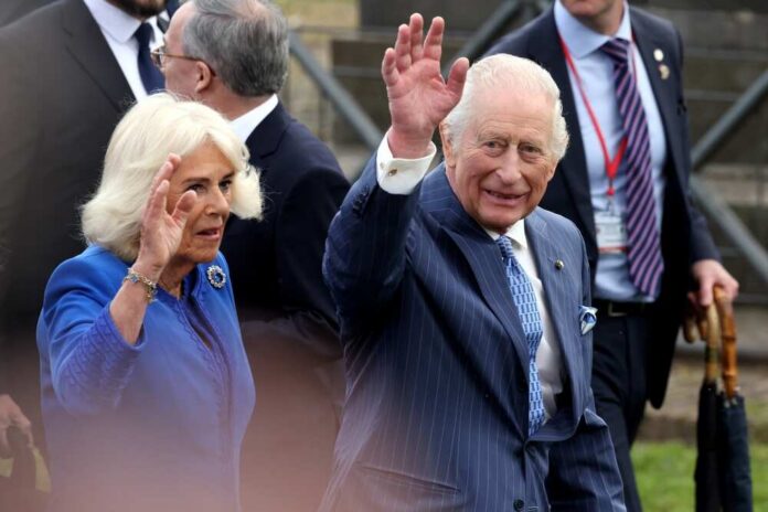 Royal couple waving to the crowd during a public event