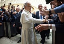 Pope interacting with a crowd of people taking photos