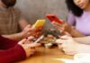 Group of friends sitting at a table, each using their smartphones