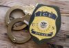 Second MURDER: Illegal Immigrant Kills Again ICE officer badge next to handcuffs on a wooden surface