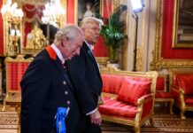 Two men in formal attire walking through a lavishly decorated room
