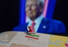 Map of Iran with push pins and a blurred figure in the background