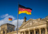 German flag flying in front of the Reichstag building in Berlin