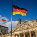 German flag flying in front of the Reichstag building in Berlin