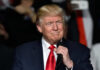 Donald Trump speaking at a rally with a microphone