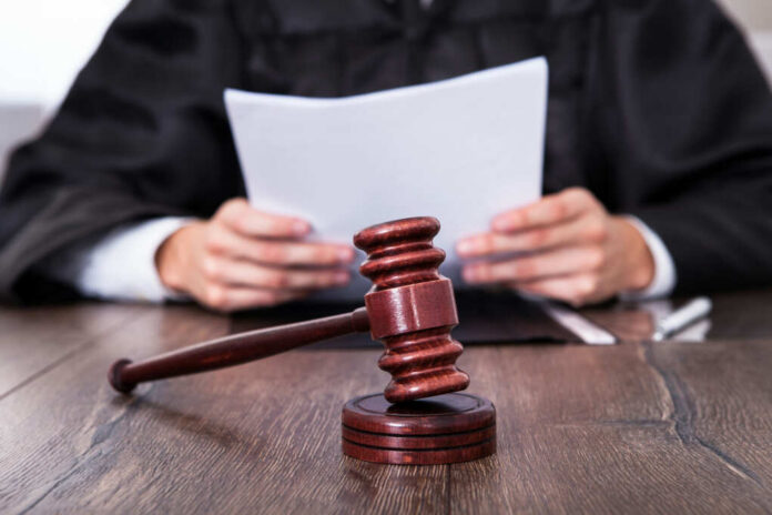 shutterstock164106293jpg A judge holding documents with a gavel in the foreground