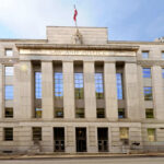Facade of a government building with the words Law and Justice and a statue on top