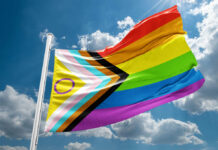 Faith Versus Mandate: Pride Flag Battle Hits Federal Court A colorful pride flag waving against a blue sky with clouds