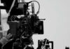 Close-up of a film camera with various cables and equipment in a studio setting