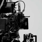 Close-up of a film camera with various cables and equipment in a studio setting