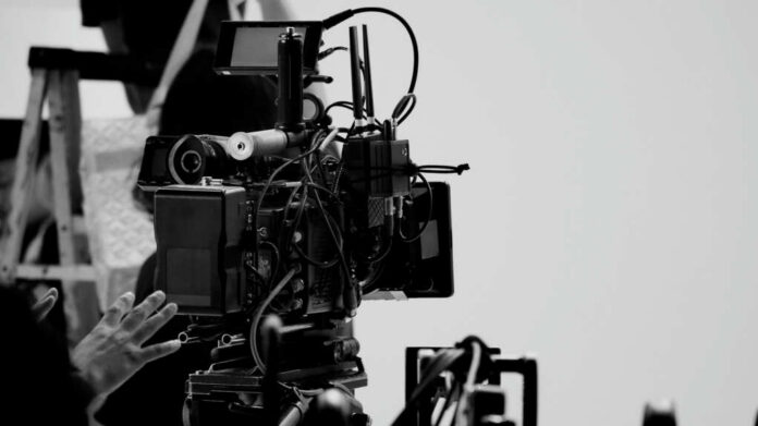 Close-up of a film camera with various cables and equipment in a studio setting