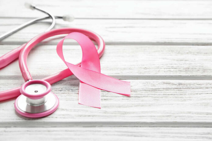 Pink,Ribbon,And,Stethoscope,On,Wooden,Background,,Closeup.,Breast,Cancer A pink ribbon next to a stethoscope on a wooden surface
