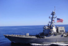 Navy Engages Iranian Vessels in Blockade Drama A naval destroyer sailing in the ocean with an American flag