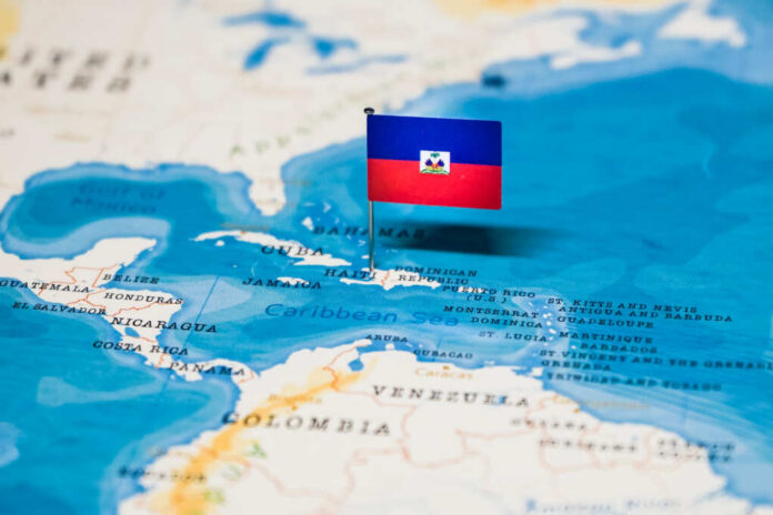 shutterstock_1326826088.jpg A small flag of Haiti pinned on a map of the Caribbean Sea
