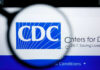 CRUISE DISASTER: Virus Outbreak Alarms CDC Magnifying glass focusing on the CDC logo on a computer screen