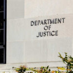 Sign on the exterior wall of the Department of Justice building