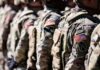 Phone Apps Expose Bases — Congress Panics Line of soldiers in military uniforms with American flag patches