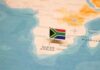 A small South African flag placed on a map of Africa