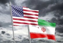 Monarchists Blast Iran Deal — ‘Appeasement?’ Flags of the United States and Iran waving against a cloudy sky