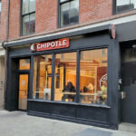 Exterior view of a Chipotle restaurant with customers inside