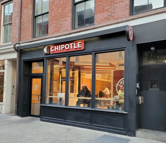 Exterior view of a Chipotle restaurant with customers inside