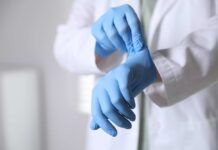 Unsolved Amnesia Mystery: Drive Wipe Raises Suspicions A medical professional putting on blue gloves in a clinical setting