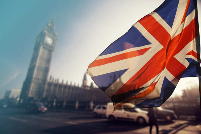 Uk,Flag,With,Big,Ben,And,House,Of,Parliament,In British flag waving in front of Big Ben in London