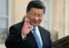 Axis Tightens: Xi Heads To Pyongyang A political leader in formal attire smiling and waving