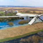 Bomber Bases Breached—No One Saw It Coming A military drone flying over a rural landscape with a river