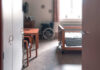 View of a hospital room featuring a patient bed and a wheelchair