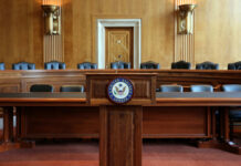 GOP Meltdown Over Mysterious $1.8B DOJ Pot Wooden podium with the United States Senate seal in an empty Senate chamber