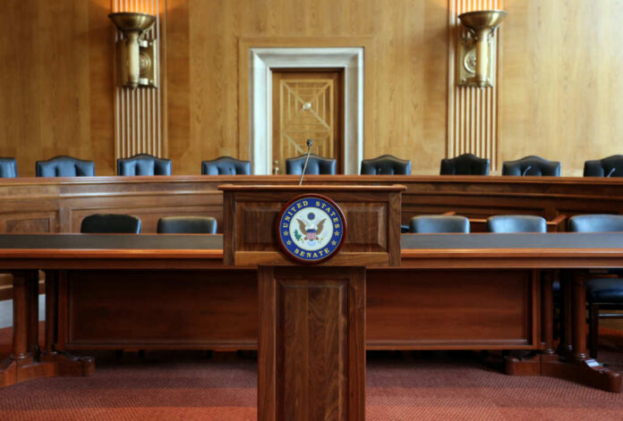 shutterstock686344315jpg Wooden podium with the United States Senate seal in an empty Senate chamber