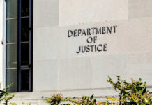Judge Reopens Trump-vs-DOJ Deal Sign on the exterior wall of the Department of Justice building