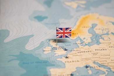 shutterstock_2324819355 A map of Europe with a small flag of the United Kingdom pinned on it