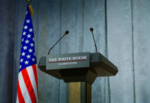 Deal Or Strike: Trump’s Stark Ultimatum Press podium with microphones and American flag in the background